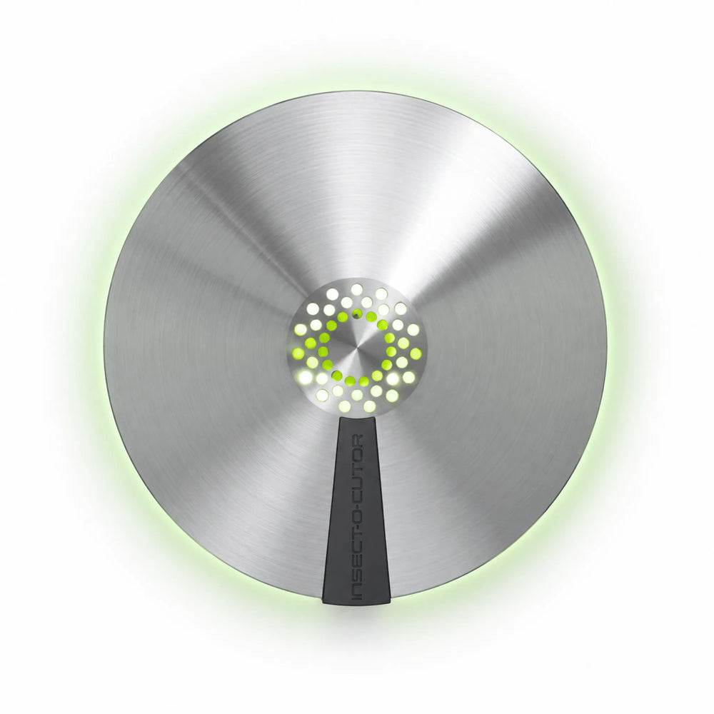 Insectocaptor Aura de Insect-O-Cutor, trampa de luz ultravioleta para moscas y otros insectos voladores, con diseño circular moderno, elegante y discreto. Ideal para espacios comerciales y zonas expuestas al público. Disponible en acabado negro mate o acero inoxidable, incorpora tecnología UV Synergetic® con emisión de luz de 360° para atraer y capturar insectos eficazmente. Su placa adhesiva oculta garantiza una captura higiénica y discreta, con aprovechamiento del 100% de la superficie adhesiva. Instalac